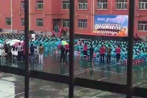孩子雨中坚持演出，老师打伞守护背后的故事